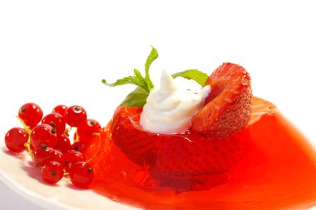 Fruit jelly decorated by a currant and whipped cream