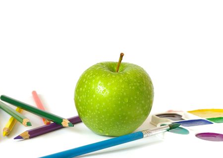 Green apple, pencils and paints  isolated on white backgroundの写真素材