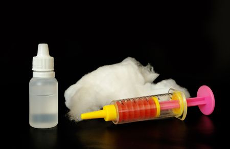 Toy syringe and cotton wool isolated on white backgroundの写真素材