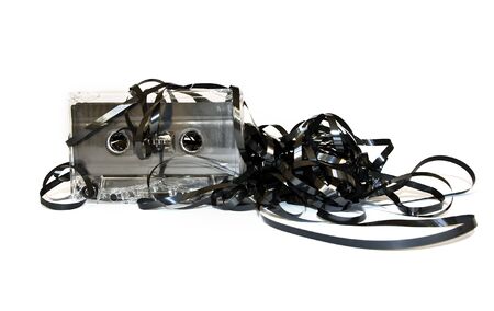 Old audio cassette with unwound tape on whiteの写真素材