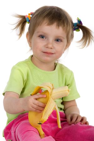 Little girl eats a banana. Studio shotの写真素材