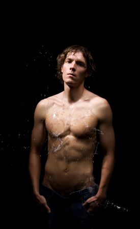 Wet beautiful man. Studio shot. Black backgroundの写真素材