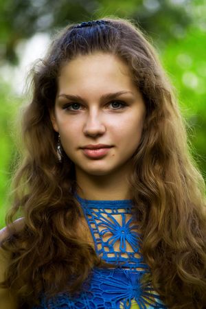 Cute young girl on nature background close-upの写真素材