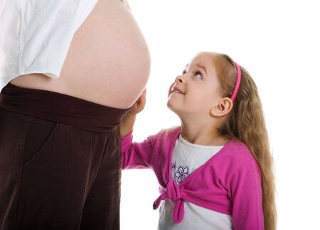 Cute little girl and her pregnant mother. Studio shotの写真素材