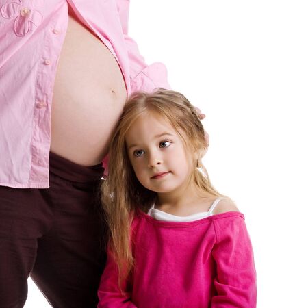 Cute little girl and her pregnant mother. Studio shotの写真素材