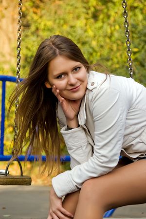 Portrait of a beautiful smiling  young woman on the swingの写真素材