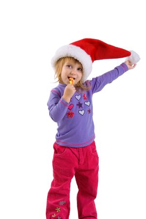 Little girl in santa claus hat with a bright lollipopの写真素材
