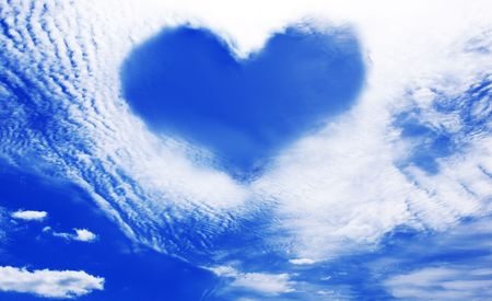 White clouds making a heart shape againt a blue sky の写真素材