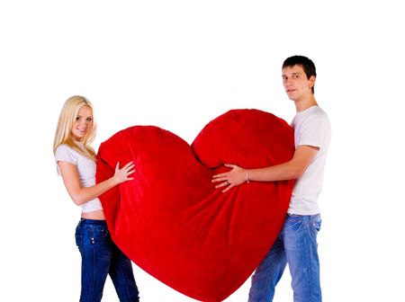 Young couple with a big heart on white backgroundの写真素材