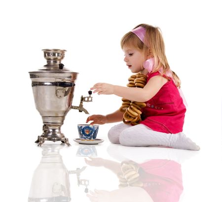 Pretty little girl near the samovar on white backgroundの写真素材
