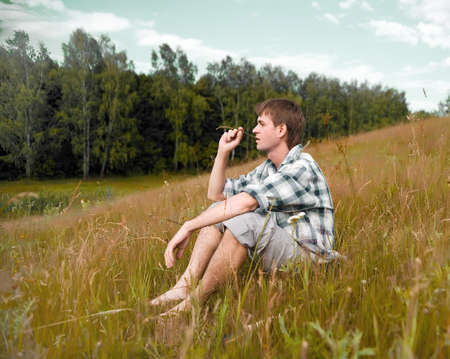 Pretty men sit on a meadowの写真素材