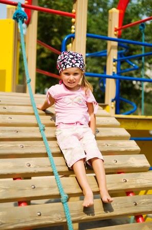 Pretty little girl on outdoor playground equipment の写真素材