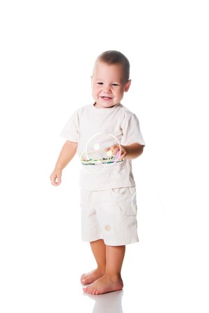Young boy catch soap bubbles on white backgroundの写真素材