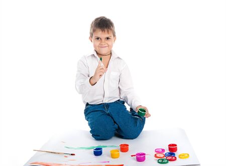 Adorable 4 year old boy covered in bright paintの写真素材