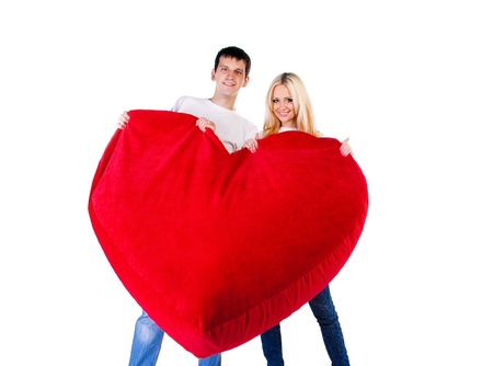 Young couple with a big heart on white backgroundの写真素材