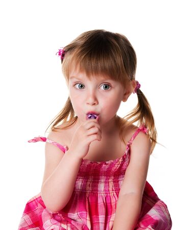 Pretty little girl with a bright lollipop. Studio shotの写真素材
