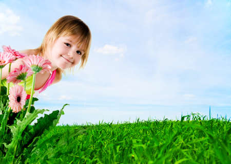 Cute little girl on a meadow backgroundの写真素材