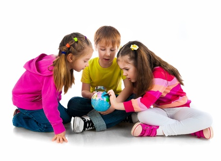 Kids with a globe of the world over white backgroundの写真素材