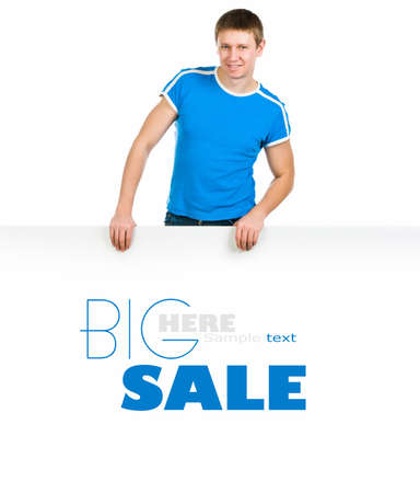 Young man standing behind blank billboard over whiteの写真素材