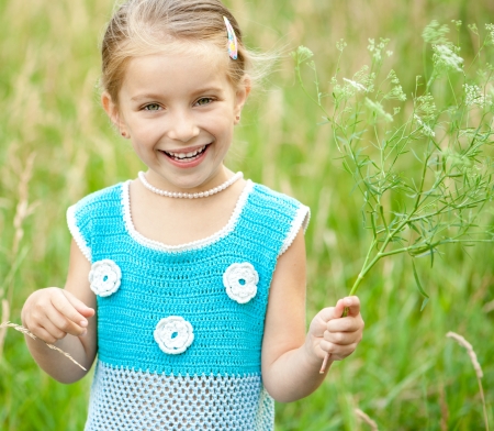 Cute little girl  on the meadow in spring dayの写真素材