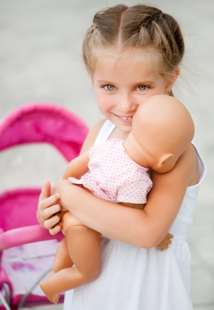 Cute little girl with her toy carriageの写真素材