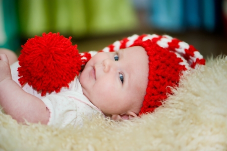 newborn girl lying in red hatの写真素材