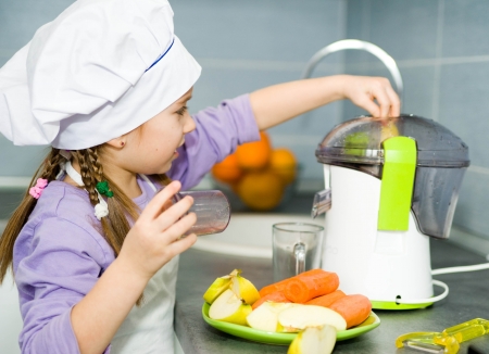 girl making fresh apple juice with a juice extractorの写真素材