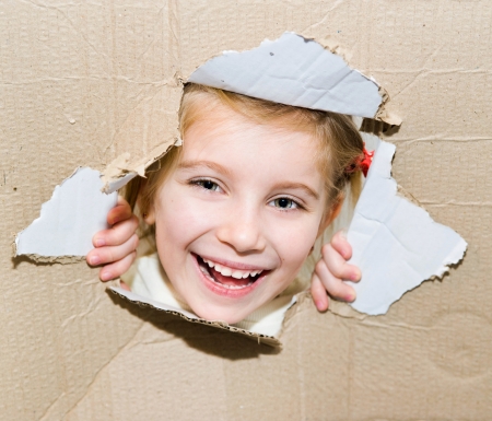 smily kid portrait in torn paper holeの写真素材