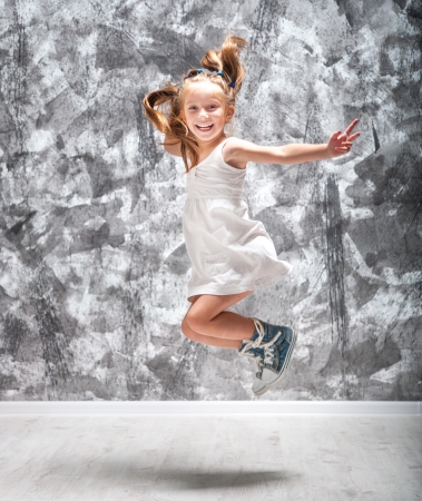 Happy little girl in white dress jump  Studio shot の写真素材