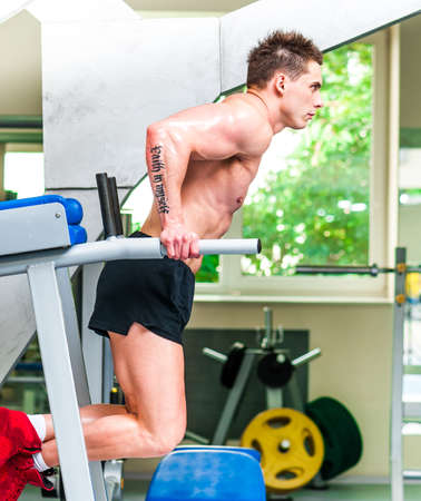 pretty sportsman is engaged in the uneven bars at the gym