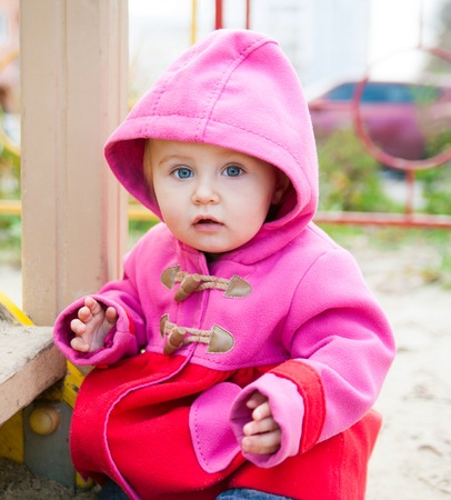 little cute girl playing at the playground in autumnの写真素材