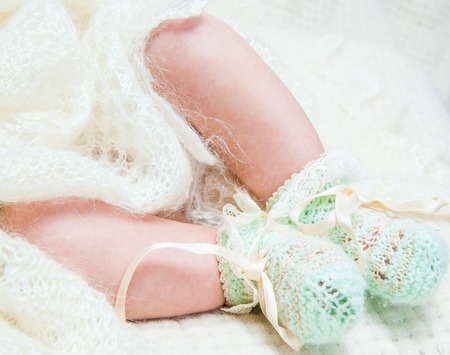 beautiful baby lying on a soft blanket in the bright interiorの写真素材