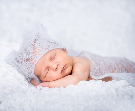 Newborn cute baby boy in a knitted hatの写真素材