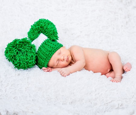 sweet newborn baby boy sleep in a green hatの写真素材