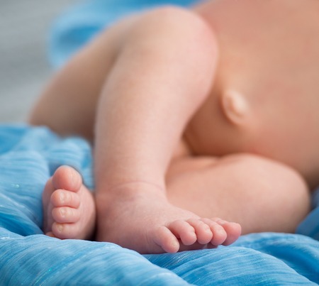 beautiful newborn baby s legs on a soft blanketの写真素材