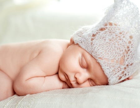 newborn boy in hat asleep
