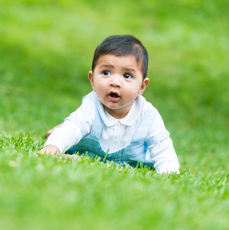 little Spanish boy on the green grassの写真素材