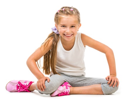 happy little girl goes in for sports  studio shot isolated on white backgroundの写真素材