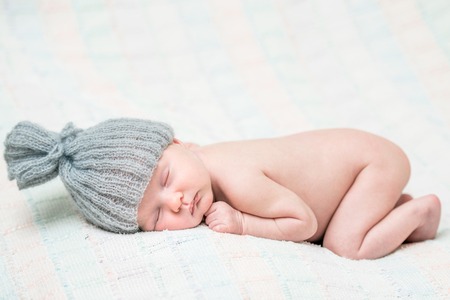 beautiful newborn baby girl sleeping in knitted capの写真素材
