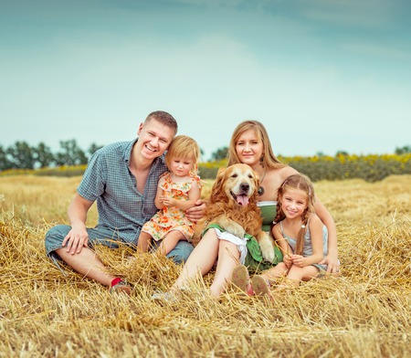 happy parents and two daughters with dogの写真素材