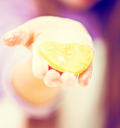 happy little girl unrolls cookie dough close-upの写真素材