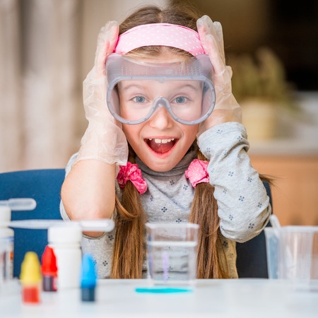 happy little girl with flasks for chemistryの写真素材