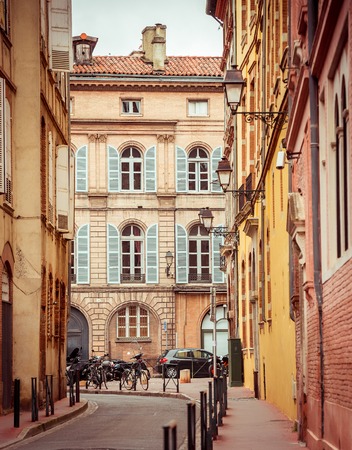 Narrow historic street with old buildings in Toulouse, Franceの写真素材