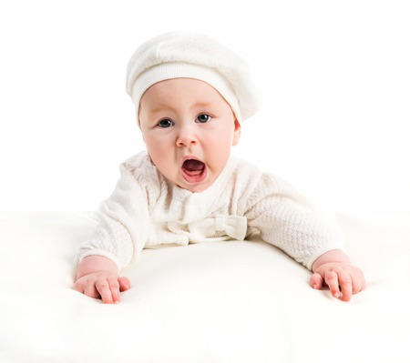 baby girl in a white cap and a jacket on a white backgroundの写真素材
