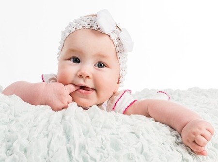baby girl with ribbon on head on white background