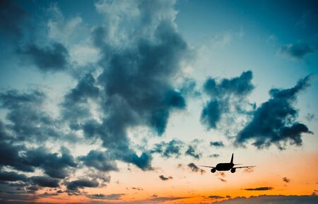 Airplane in the sky at sunsetの写真素材