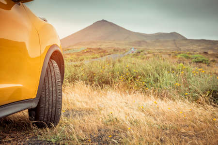 Yellow car on a background of mountainsの写真素材