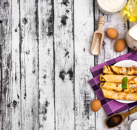 pancakes and ingredients on a wooden backgroundの写真素材