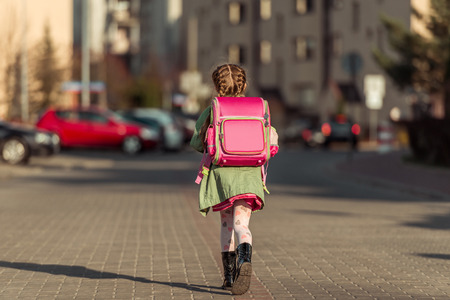 little  girl with a backpack going to schoolの写真素材