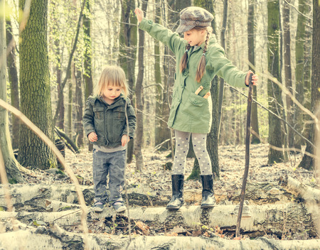 little girl in the forest with her sister. Photo in retro styleの写真素材